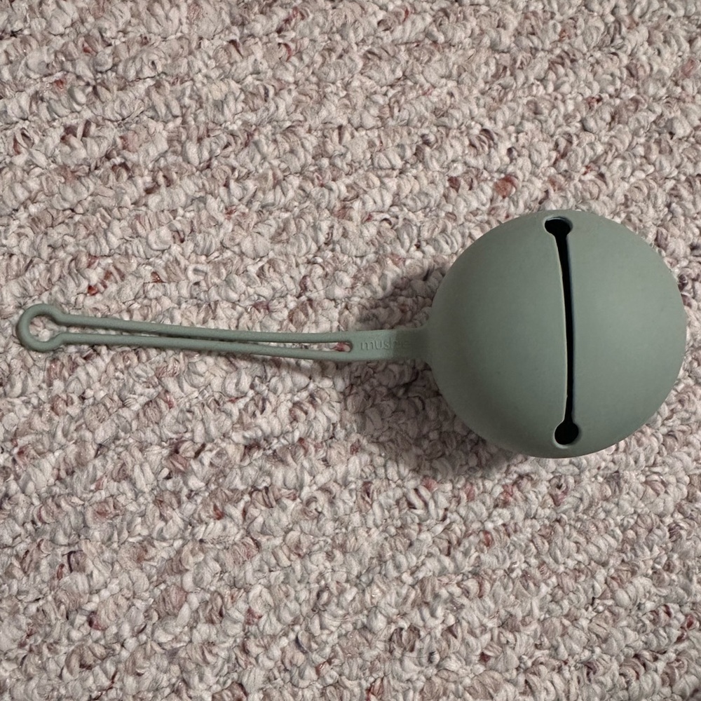Mushie green pacifier holder